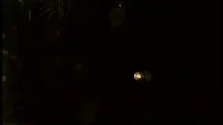 Человек в черной одежде стоит в темноте