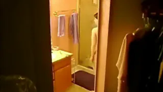 Мужчина в ванной смотрит в зеркало
